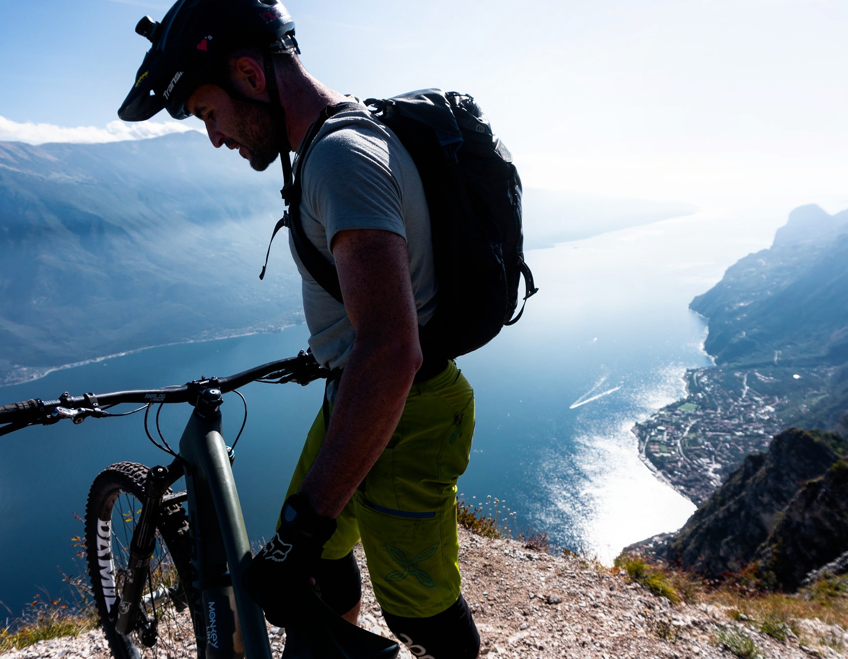 Foto di un ragazzo con la sua mountain bike con vista su un lago limpido