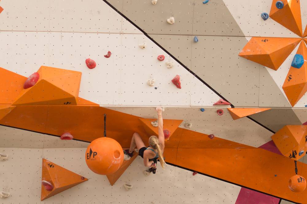 Foto di una ragazza mentre si sta arrampicando su un percorso costruito