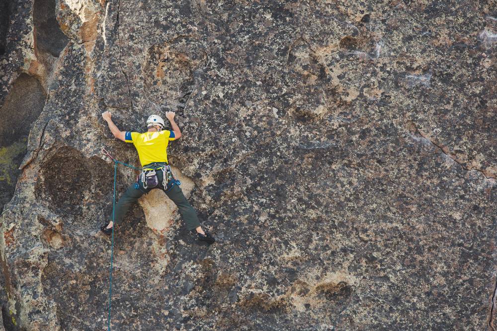 Foto di un ragazzo che i arrampica su una montagna