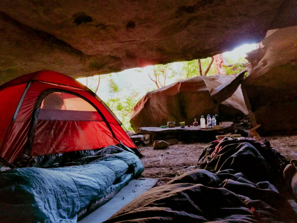 Foto di tende con all'interno delle persone dentro una grotta in montagna