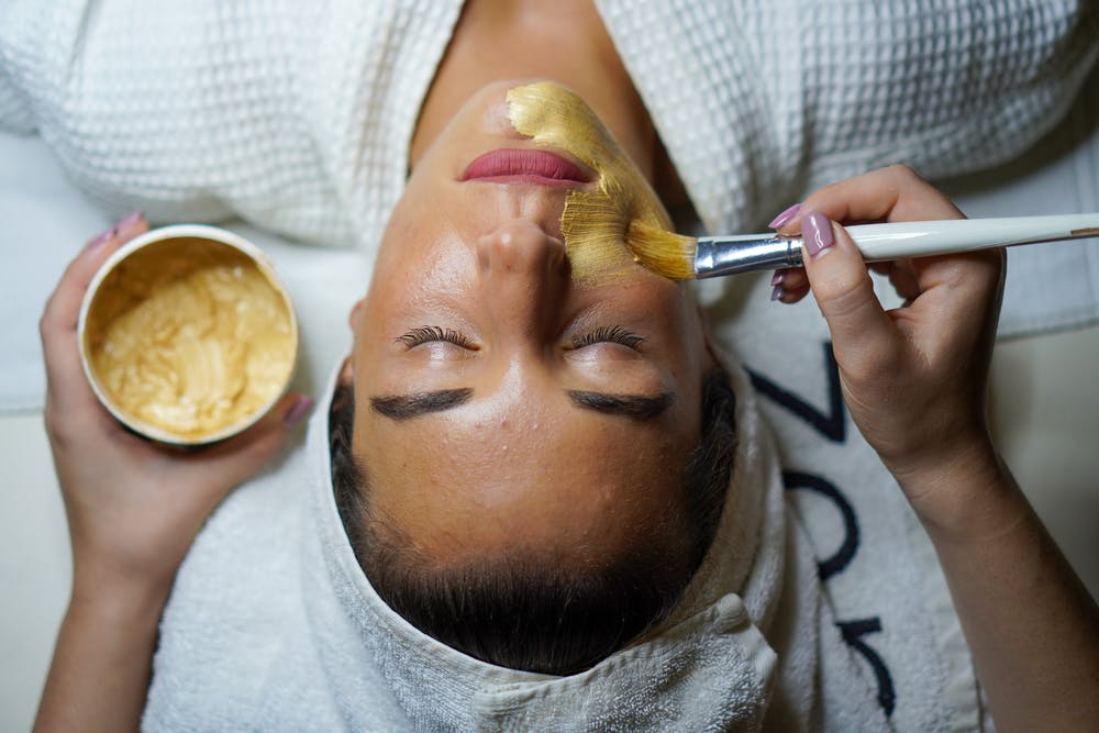 Foto di una ragazza mentre le si sta applicando una maschera di bellezza