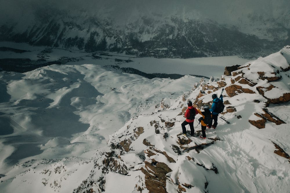 Vista montagne di neve e tre ragazzi fermi a contemplare il paesaggio