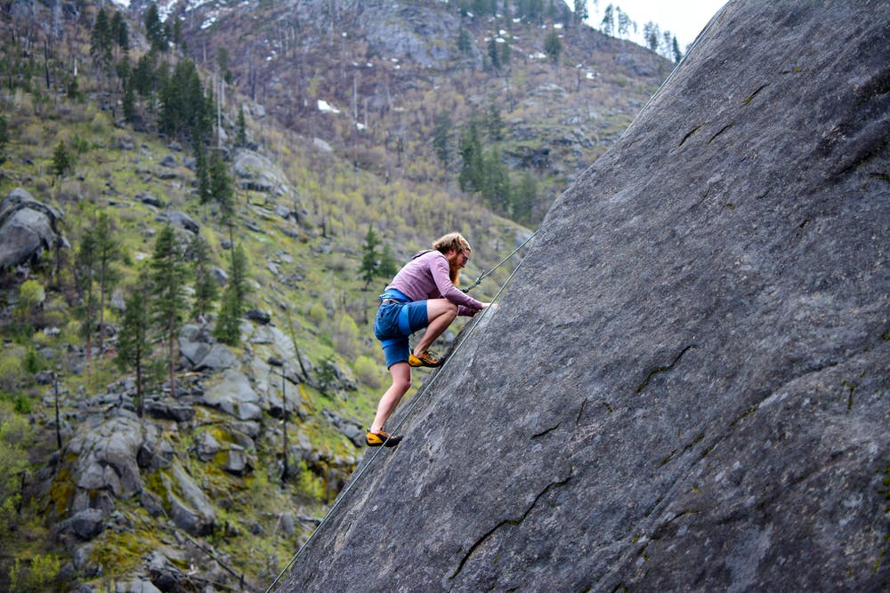 Foto di un ragazzo mentre si arrampica su una montagna