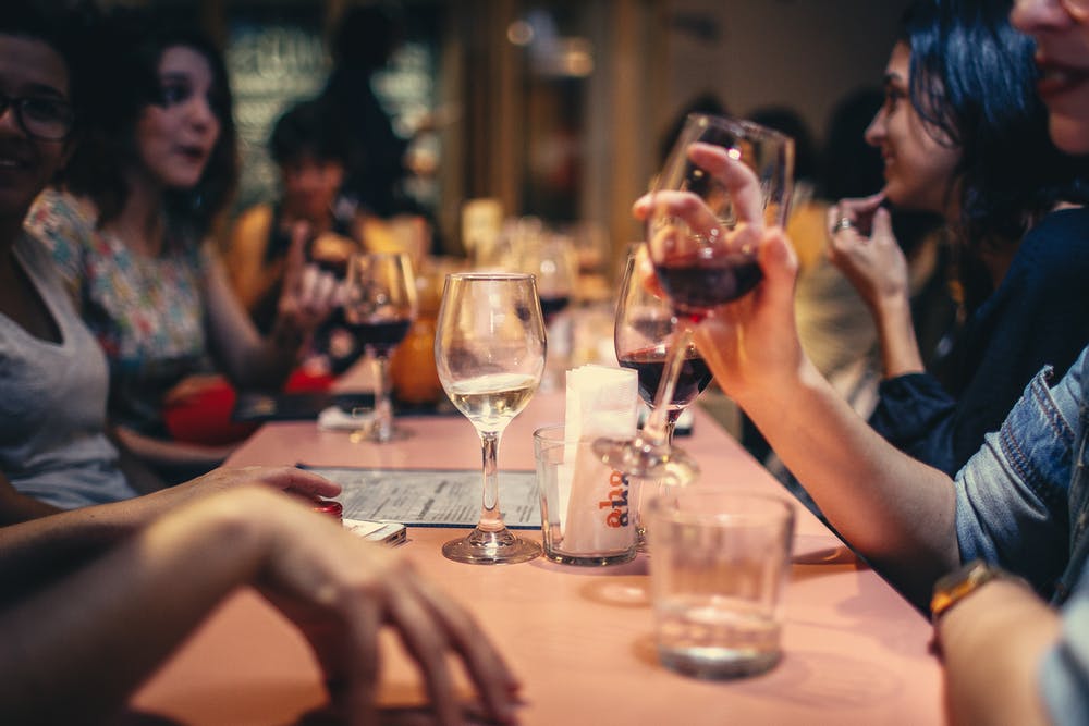 Foto di un gruppo di amici a tavola mentre chiacchierano