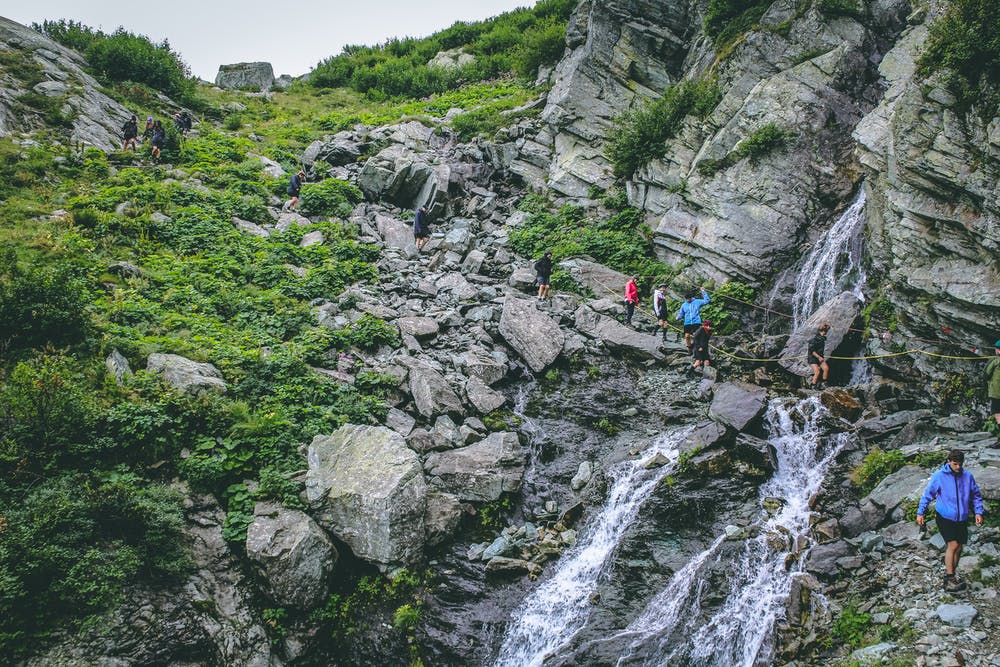 Vista di montagne verdi ed un percorso che stanno facendo dei ragazzi