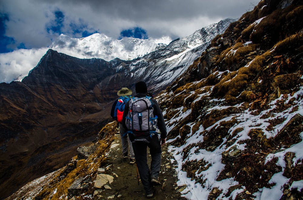 Foto di due ragazzi mentre fanno un percorso in montagna