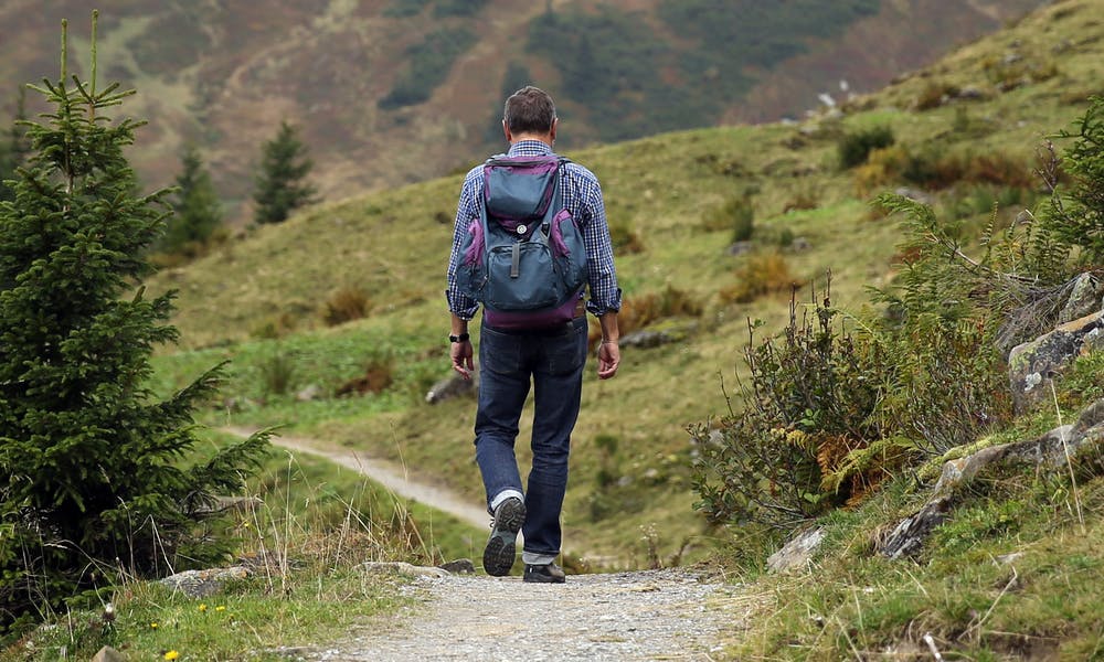 Foto di un uomo mentre percorre un sentiero di montagna